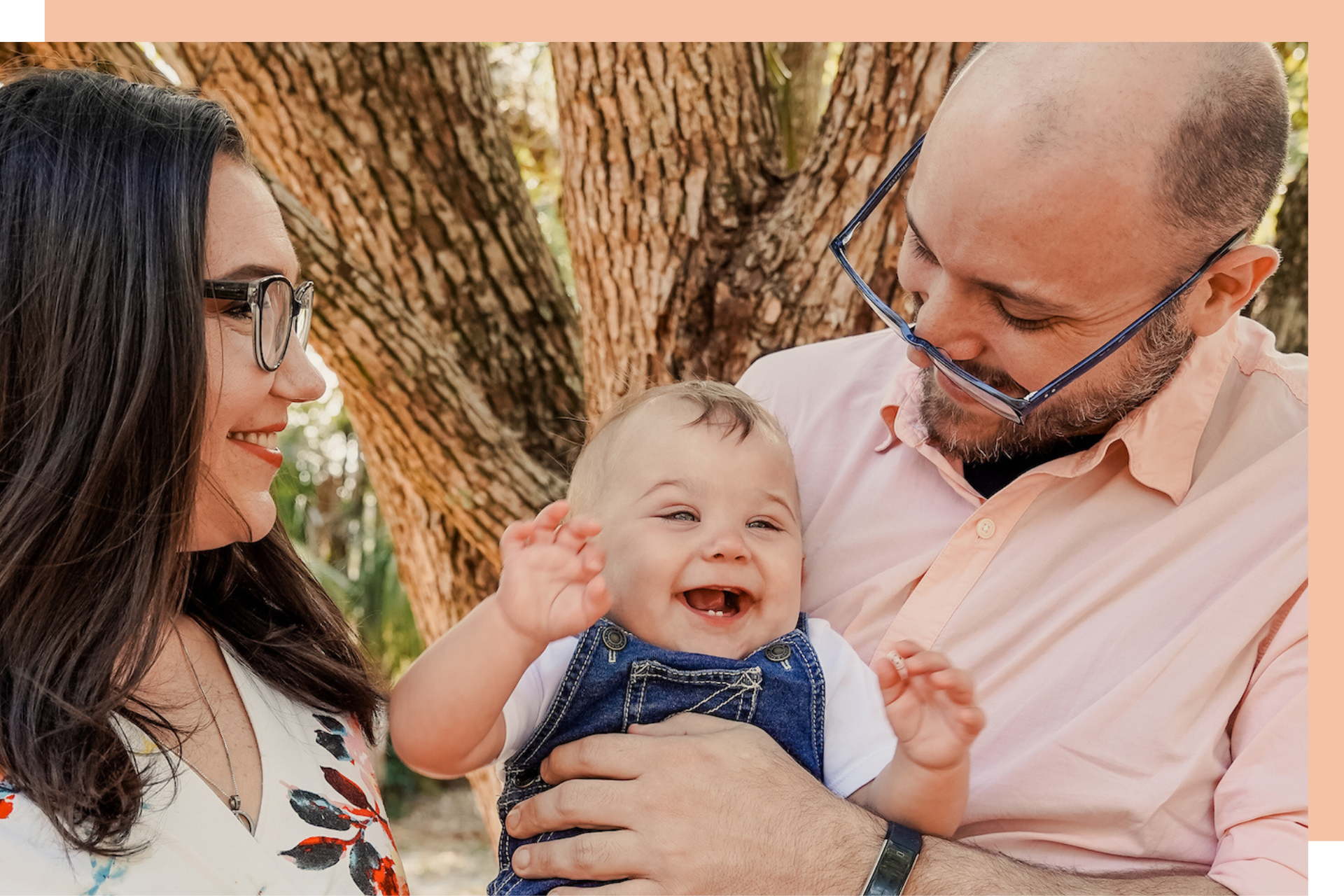couple with smiling baby-pink background